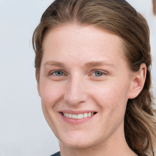 Joyful white young-adult female with medium  brown hair and grey eyes