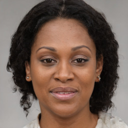 Joyful latino adult female with medium  brown hair and brown eyes