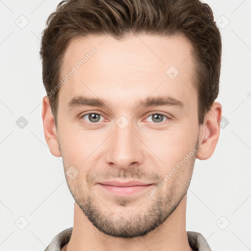 Joyful white young-adult male with short  brown hair and grey eyes