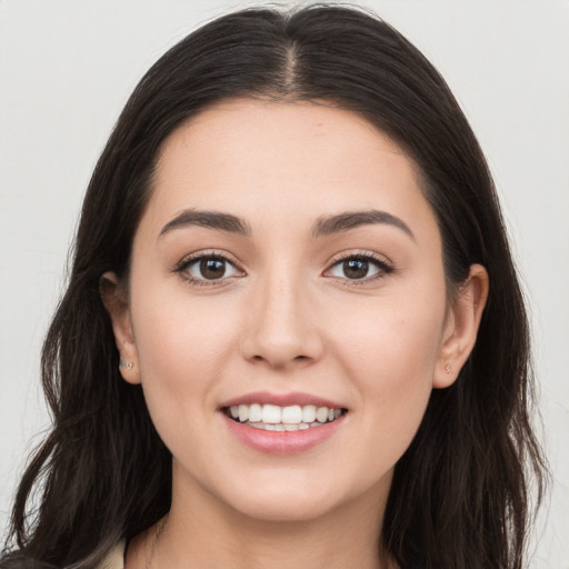 Joyful white young-adult female with long  brown hair and brown eyes