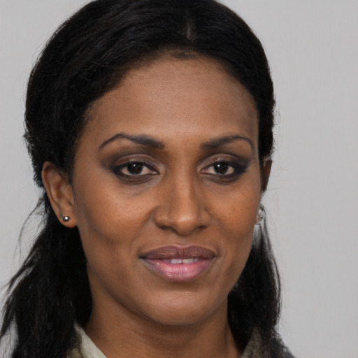 Joyful black young-adult female with long  brown hair and brown eyes