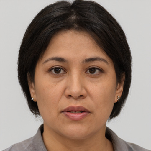Joyful asian adult female with medium  brown hair and brown eyes