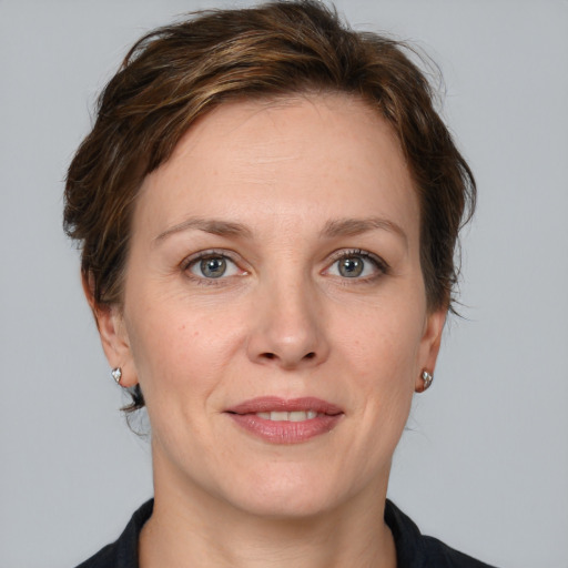 Joyful white adult female with medium  brown hair and grey eyes