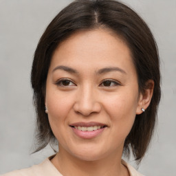 Joyful asian young-adult female with medium  brown hair and brown eyes