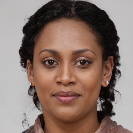 Joyful black young-adult female with long  brown hair and brown eyes