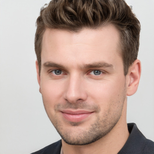 Joyful white young-adult male with short  brown hair and grey eyes