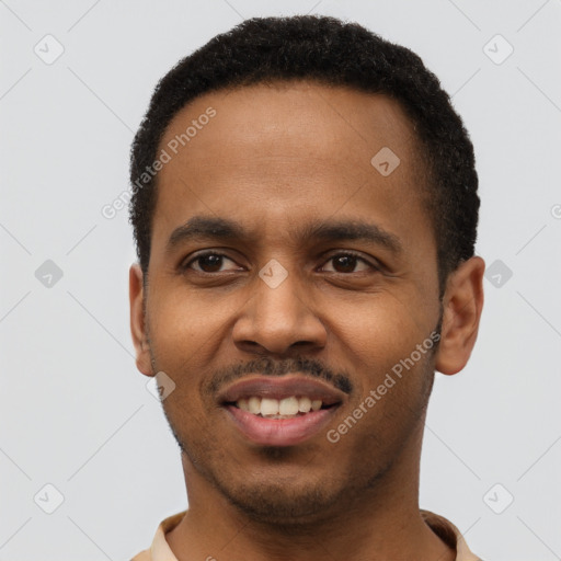 Joyful black young-adult male with short  black hair and brown eyes