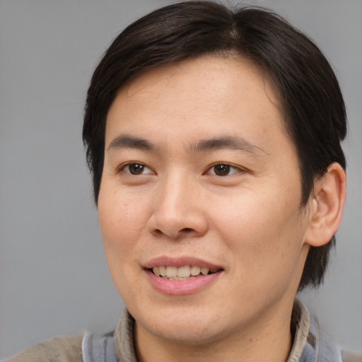 Joyful asian young-adult male with medium  brown hair and brown eyes