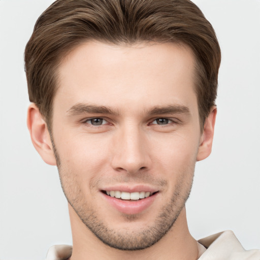 Joyful white young-adult male with short  brown hair and grey eyes