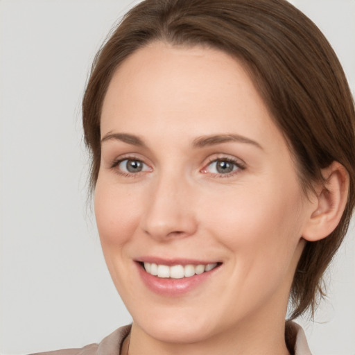 Joyful white young-adult female with medium  brown hair and grey eyes