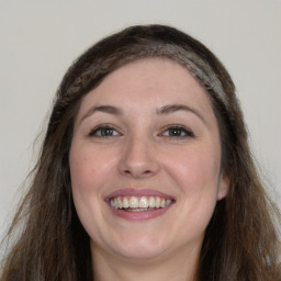 Joyful white young-adult female with long  brown hair and grey eyes