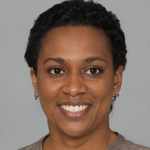 Joyful black young-adult female with short  black hair and brown eyes