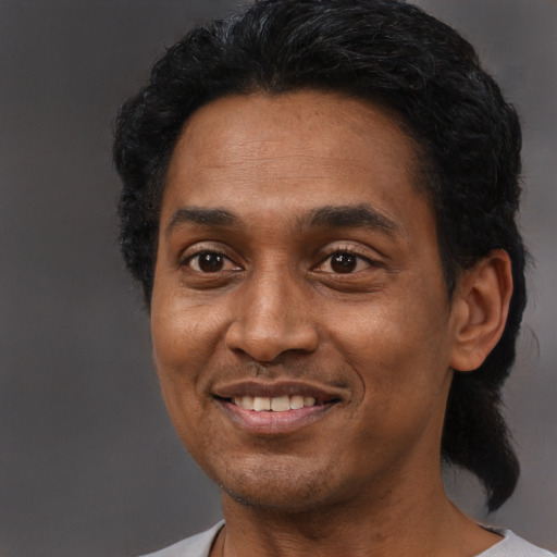 Joyful black adult male with short  black hair and brown eyes