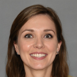 Joyful white young-adult female with long  brown hair and blue eyes