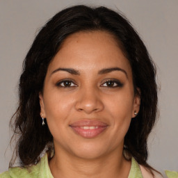 Joyful latino young-adult female with medium  brown hair and brown eyes