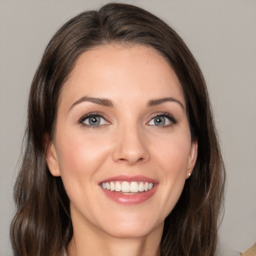 Joyful white young-adult female with medium  brown hair and grey eyes