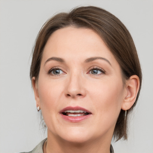 Joyful white adult female with medium  brown hair and grey eyes