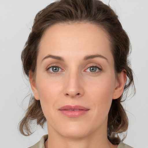 Joyful white young-adult female with medium  brown hair and grey eyes