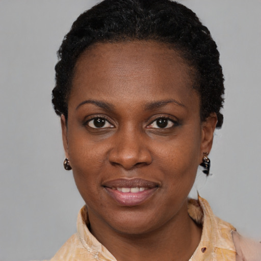Joyful black young-adult female with short  black hair and brown eyes