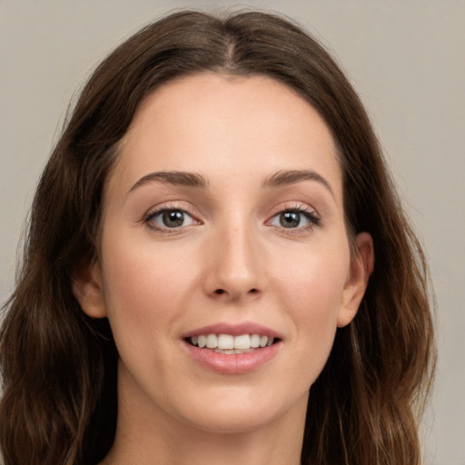 Joyful white young-adult female with long  brown hair and green eyes