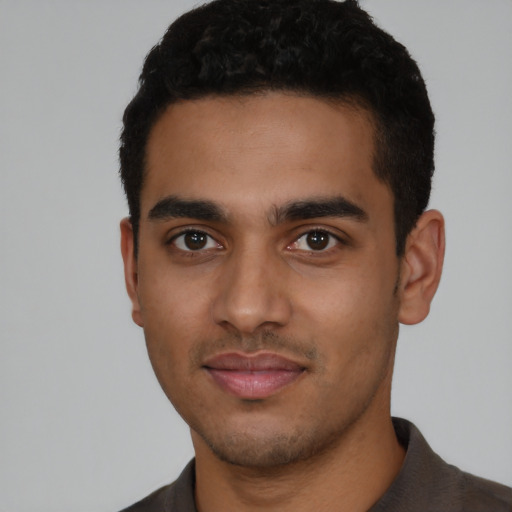 Joyful latino young-adult male with short  black hair and brown eyes