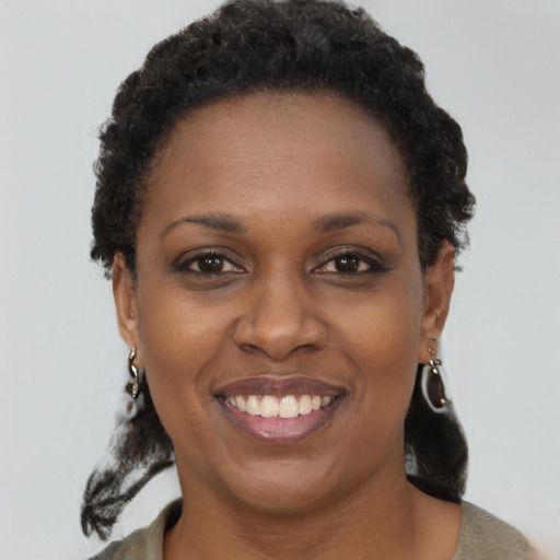 Joyful black young-adult female with short  brown hair and brown eyes