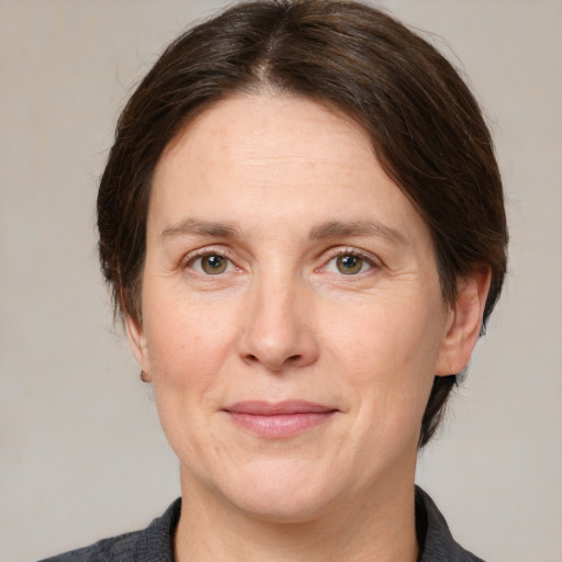 Joyful white adult female with medium  brown hair and grey eyes