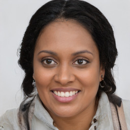 Joyful black young-adult female with long  brown hair and brown eyes