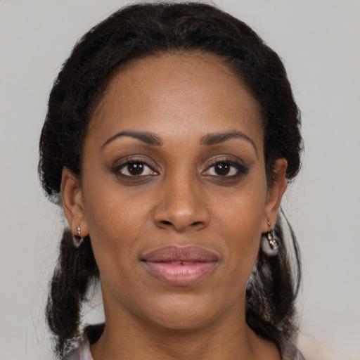 Joyful black adult female with medium  brown hair and brown eyes