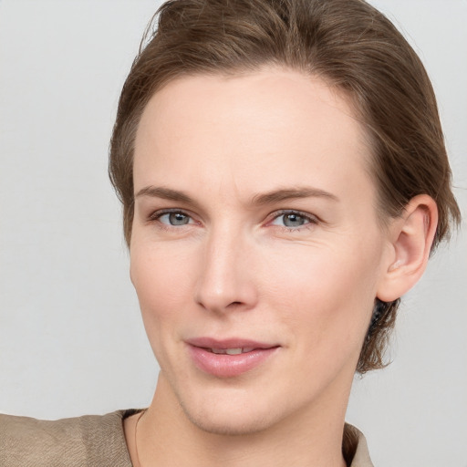 Joyful white young-adult female with medium  brown hair and grey eyes