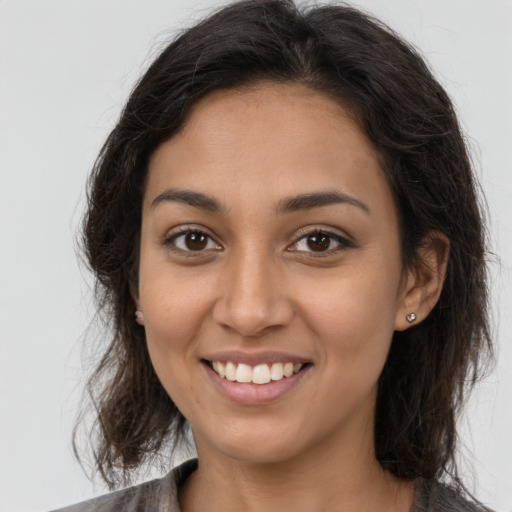 Joyful latino young-adult female with long  brown hair and brown eyes