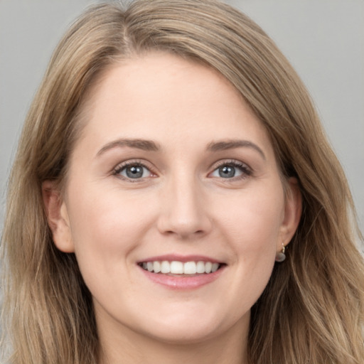 Joyful white young-adult female with long  brown hair and grey eyes