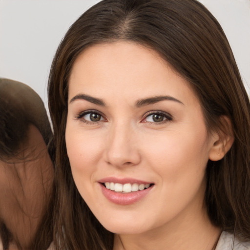 Joyful white young-adult female with long  brown hair and brown eyes