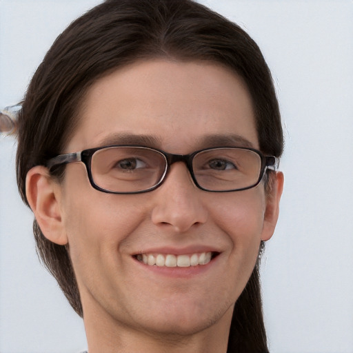 Joyful white young-adult male with long  brown hair and grey eyes