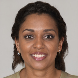 Joyful black adult female with medium  brown hair and brown eyes