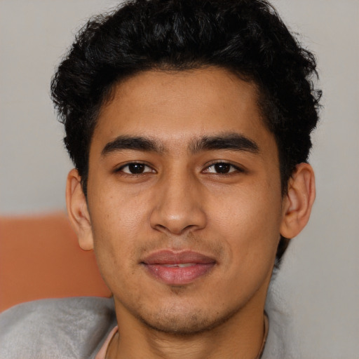 Joyful latino young-adult male with short  brown hair and brown eyes