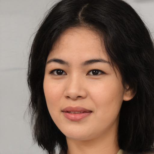 Joyful asian young-adult female with long  black hair and brown eyes