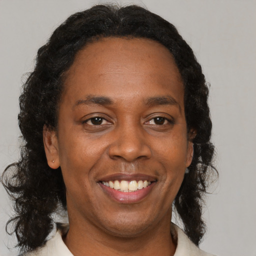 Joyful black adult female with medium  brown hair and brown eyes