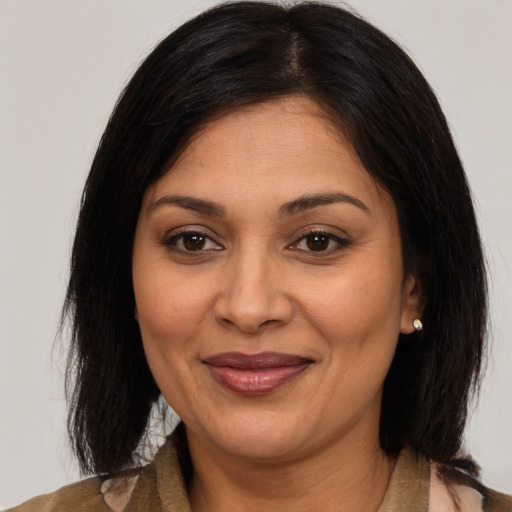 Joyful latino adult female with medium  brown hair and brown eyes