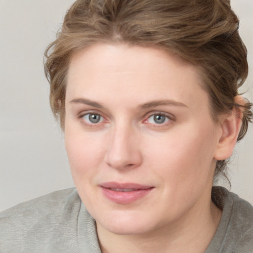 Joyful white young-adult female with medium  brown hair and blue eyes