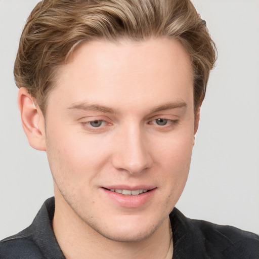 Joyful white young-adult male with short  brown hair and grey eyes