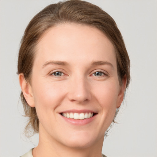 Joyful white young-adult female with medium  brown hair and grey eyes