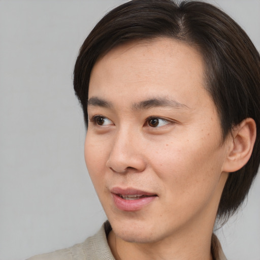 Joyful asian young-adult male with short  brown hair and brown eyes