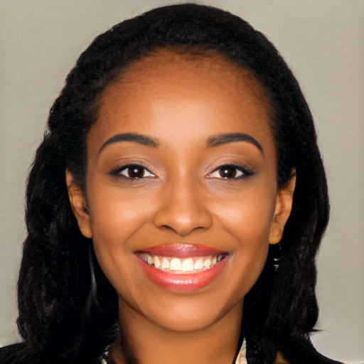 Joyful black young-adult female with long  black hair and brown eyes