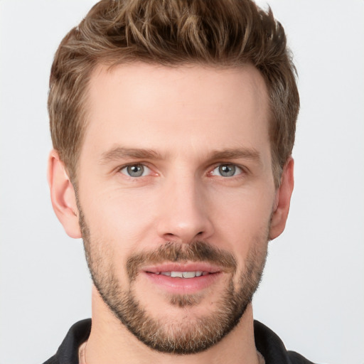 Joyful white young-adult male with short  brown hair and grey eyes