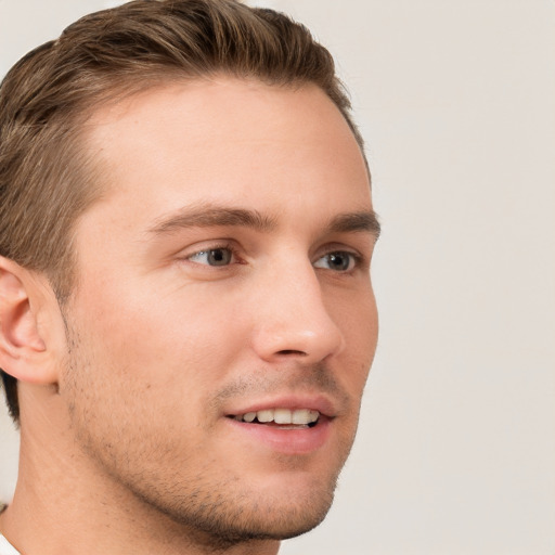 Joyful white young-adult male with short  brown hair and grey eyes