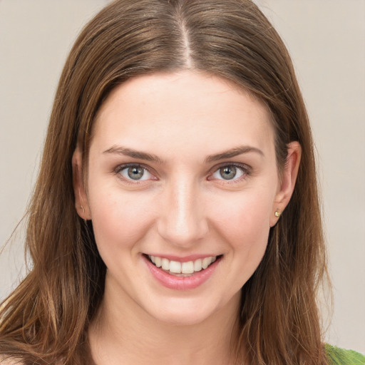 Joyful white young-adult female with long  brown hair and green eyes