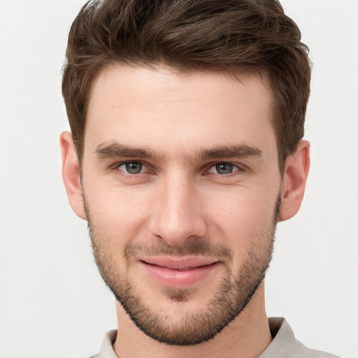 Joyful white young-adult male with short  brown hair and grey eyes