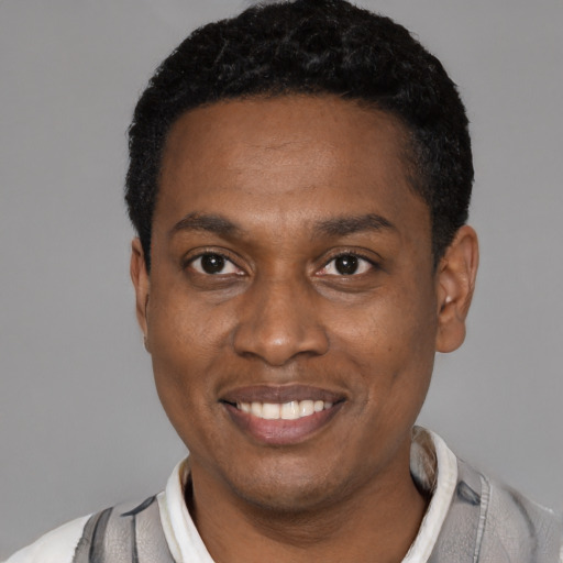 Joyful latino young-adult male with short  black hair and brown eyes