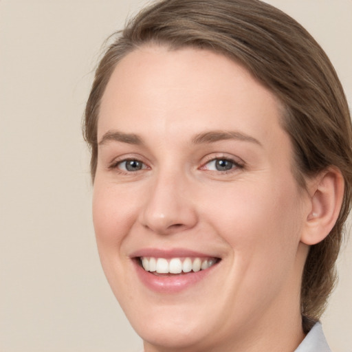 Joyful white young-adult female with medium  brown hair and blue eyes